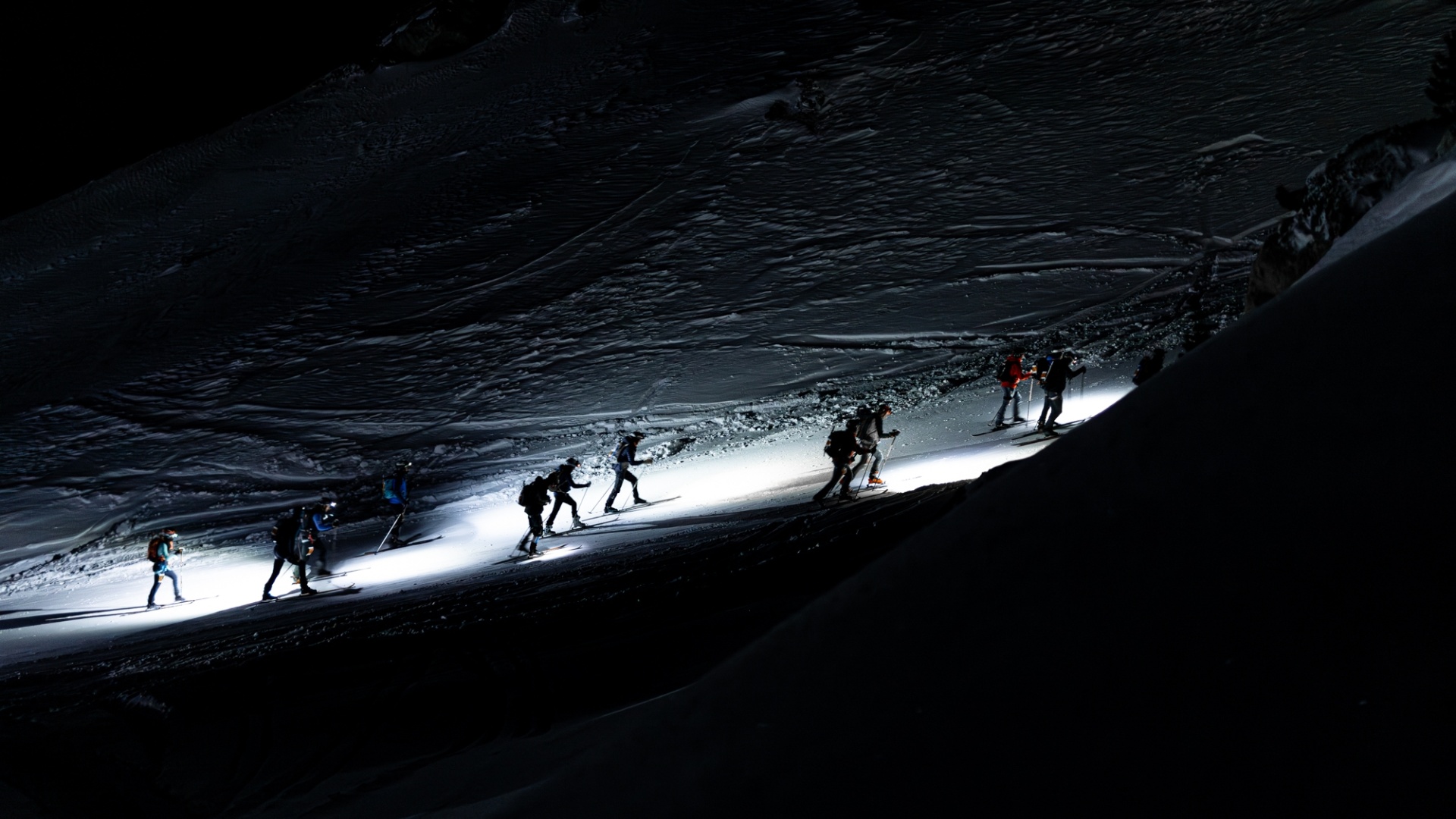 Ski mountaineers climbing at night during the Patrouille des Glaciers in Switzerland